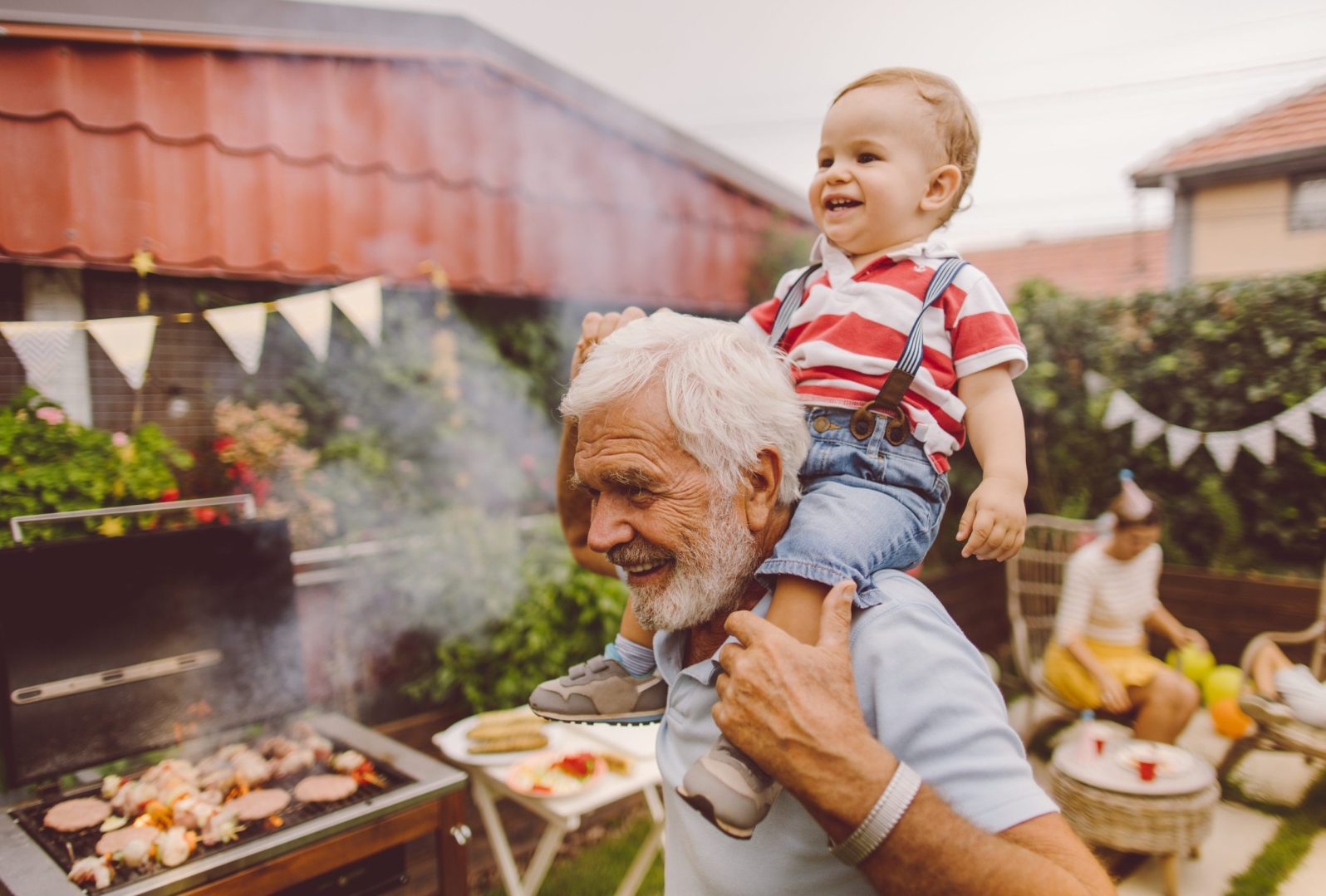 Christian grandfather laughing with his grandson at a family gathering, reflecting the lifetime income and generational legacy of a charitable remainder trust